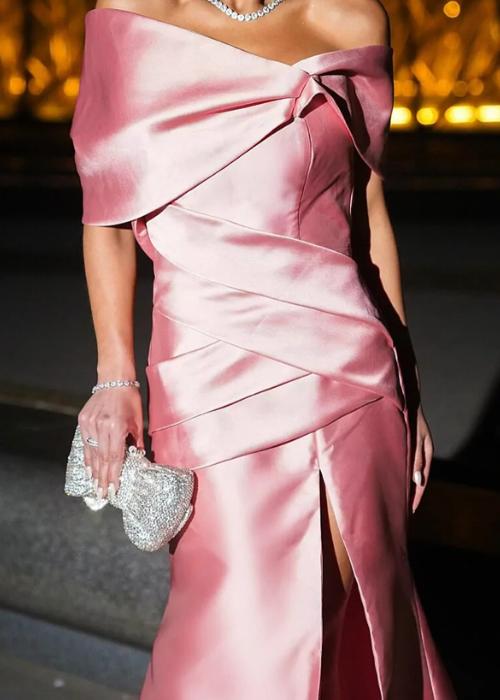 Pink satin off-shoulder mermaid evening gown with a structured draped bodice and a high leg slit.