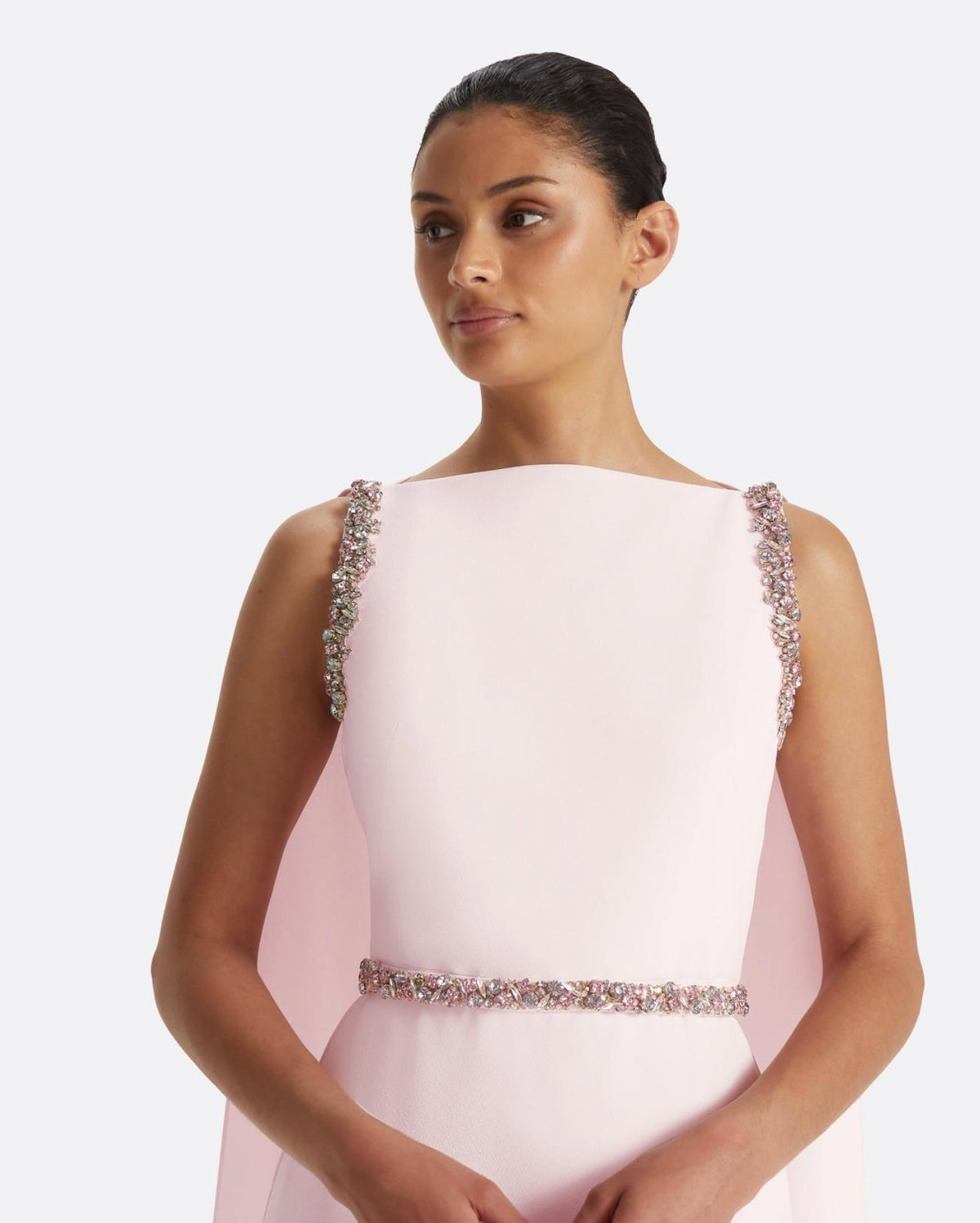 Pale pink floor-length crepe gown with multi-pastel crystal shoulder and waist embellishments and a dramatic cape back.