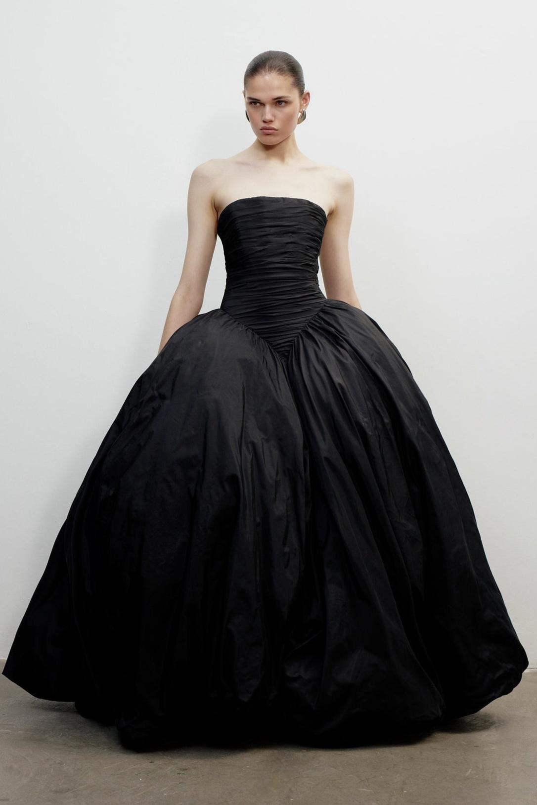 Strapless black taffeta A-line gown with a fitted, ruched bodice and a voluminous, sweeping skirt for formal occasions.