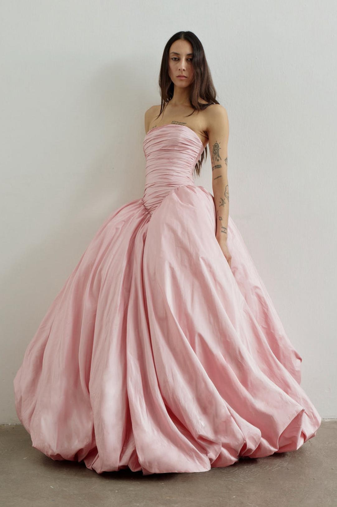 Strapless pink taffeta A-line gown with a ruched bodice and voluminous, sweeping skirt for formal occasions.