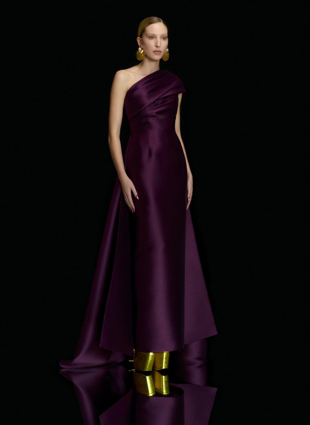 Deep purple satin one-shoulder gown with a fitted bodice, A-line skirt, and dramatic high-low demi-train.