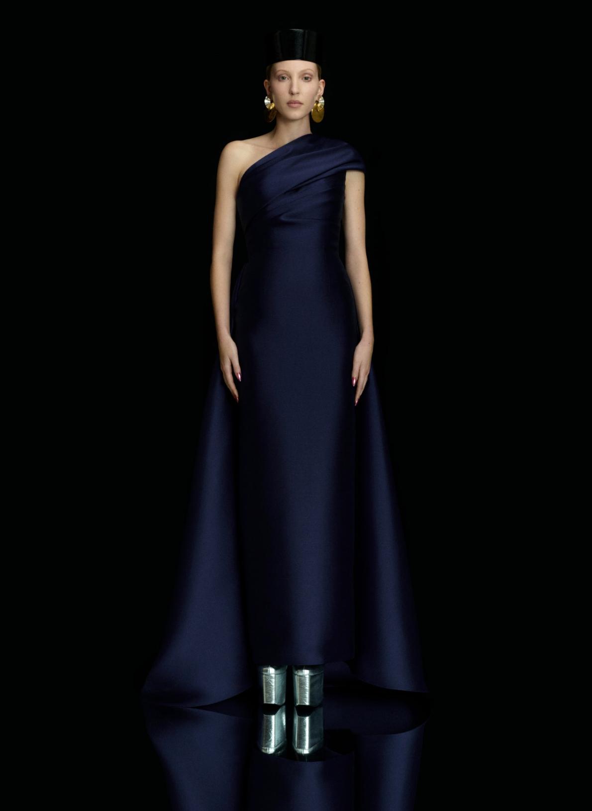 Navy blue satin one-shoulder gown with a fitted waist, A-line silhouette, and dramatic demi-train.