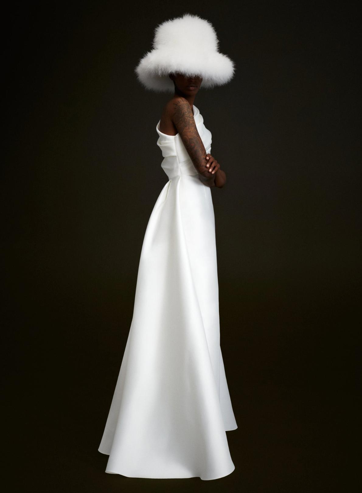 Tallulah white satin one-shoulder gown with A-line skirt and matching oversized white feathered bucket hat.